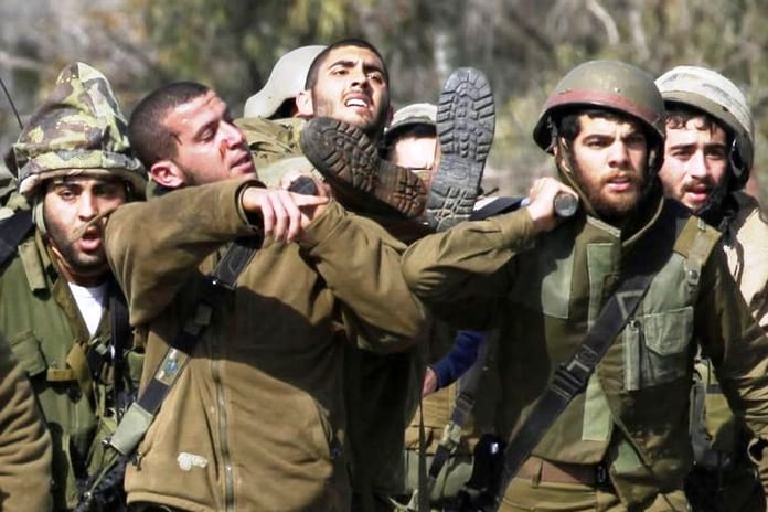 711286-des-soldats-israeliens-portent-un-de-leurs-camarades-blesse-dans-une-attaque-du-hezbollah-le-28-janv