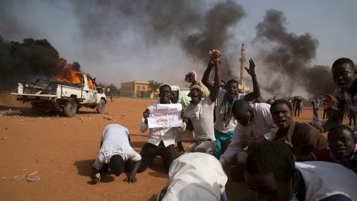 A man holds a sign during a protest against Niger President Issoufou's attendance last week at a Paris rally in support of French satirical weekly Charlie Hebdo, in Niamey
