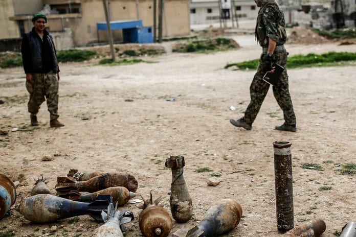 des-combattants-kurdes-syriens-marchent-le-27-mars-2015-dans-une-rue-de-kobane-au-milieu