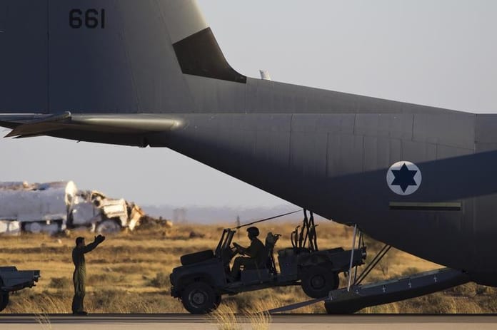 A jeep drives from a C-130J Super Hercules plane at Hatzerim air base in southern Israel