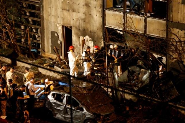 Forensic inspectors examine the site of an explosion at the headquarters of the Lebanese Blom Bank in Beirut