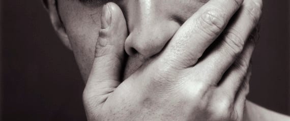 Man covering mouth with hand, portrait, close-up (B&W)