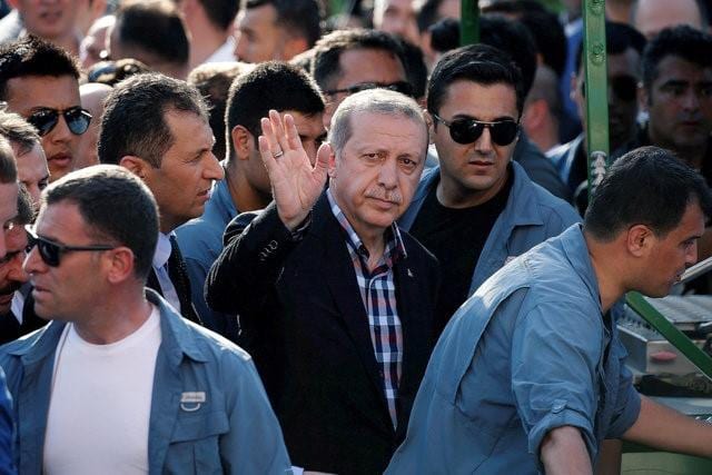 Turkish President Recep Tayyip Erdogan waves to the crowd following a funeral service for a victim of the thwarted coup in Istanbul