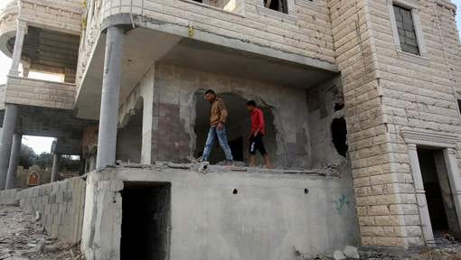 Relatives check the damage to the family house of Palestinian assailant Mohammad Tarayra after it was partially blown up by Israeli troops in the West Bank village of Bani Naem