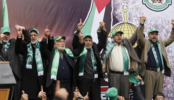 Senior Hamas leaders hold hands as they take part in a rally marking the 28th anniversary of Hamas' founding, in Gaza City