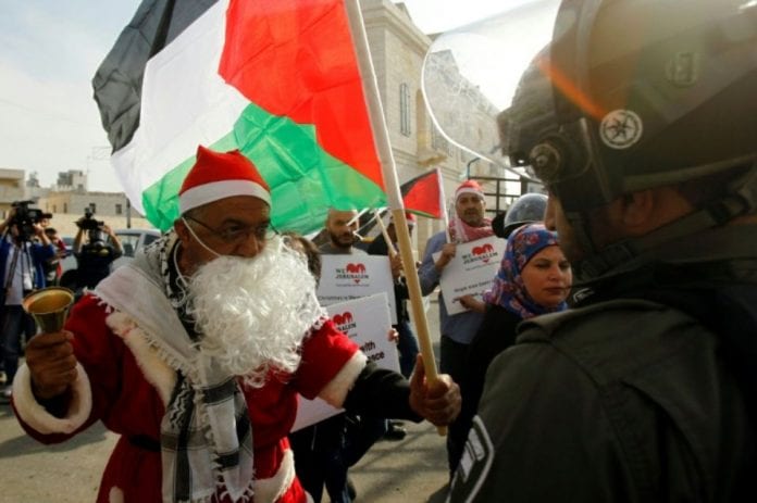 1082961-un-manifestant-palestinien-habille-en-pere-noel-s-oppose-a-un-membre-des-forces-de-l-ordre-israelien