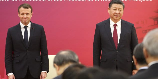 French President Emmanuel Macron (L) and Chinese President Xi Jinping (R) stand to inaugurate the first meeting of the French-Chinese business council in Beijing
