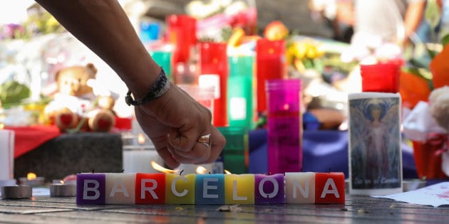 A man lights a candle in an impromptu memorial a day after a van crashed into pedestrians at Las Ramblas in Barcelona