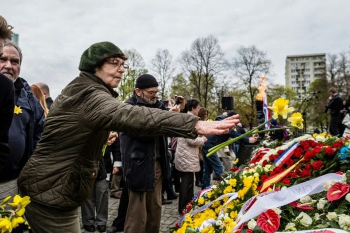 1114710-une-femme-depose-des-jonquilles-devant-le-monument-deposent-des-fleurs-devant-le-monument-aux-heros-
