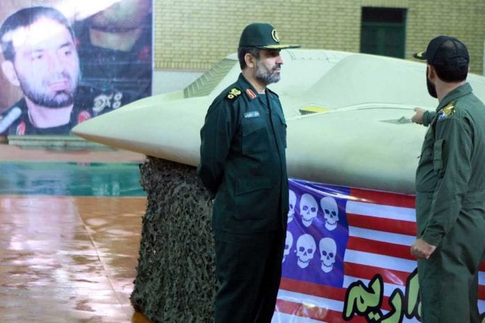 undated-picture-shows-member-of-iran-s-revolutionary-guard-pointing-at-u-s-rq-170-unmanned-spy-plane-as-he-speaks-with-hajizadeh-at-unknown-location-in-iran_5717623_1148_765