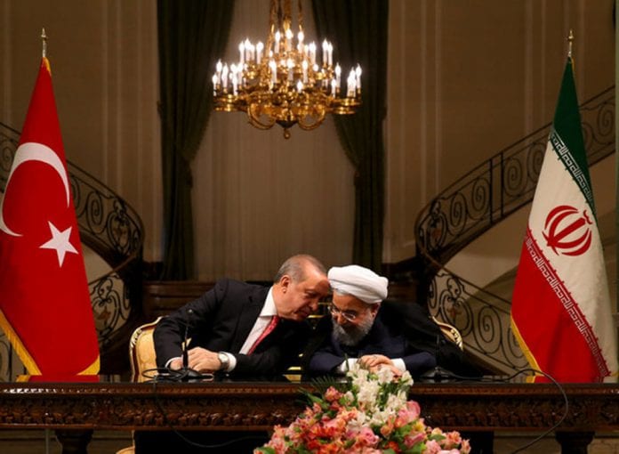 Turkish President Erdogan chats with Iranian President Rouhani during a joint news conference in Tehran