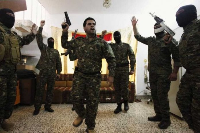 553912-fighters-from-iraq-s-shi-ite-militias-celebrate-before-departing-to-syria-from-baghdad_930_620
