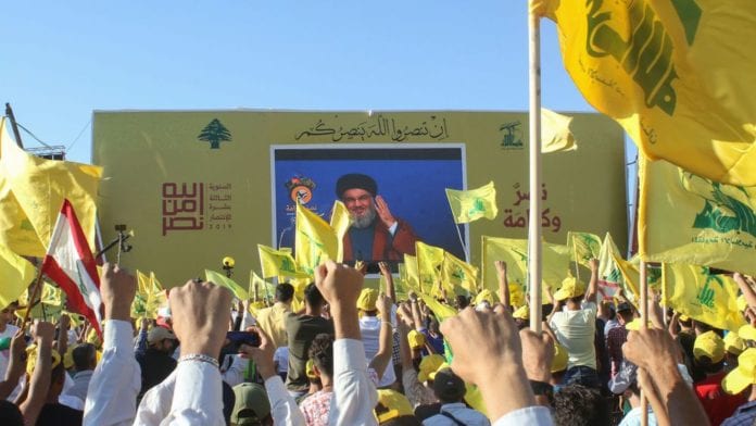 des-partisans-du-mouvement-chiite-libanais-hezbollah-brandissent-le-drapeau-du-groupe-lors-d-une-ceremonie-a-bint-jbeil-dans-le-sud-du-liban-le-16-aout-2019-pour-marquer-le-13e-anniversaire-de-