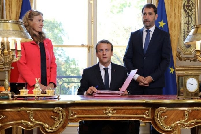 7790107913_emmanuel-macron-lors-de-la-signature-de-la-loi-moralisation-entoure-de-nicole-belloubet-et-christophe-castaner