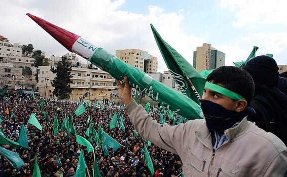 Palestinian youth holds model of Hamas-made rocket during rally in West Bank city of Hebron