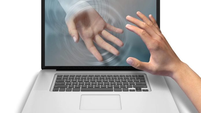 Helping,Hand,Reaches,Through,Laptop,Screen,To,Offer,Help,And
