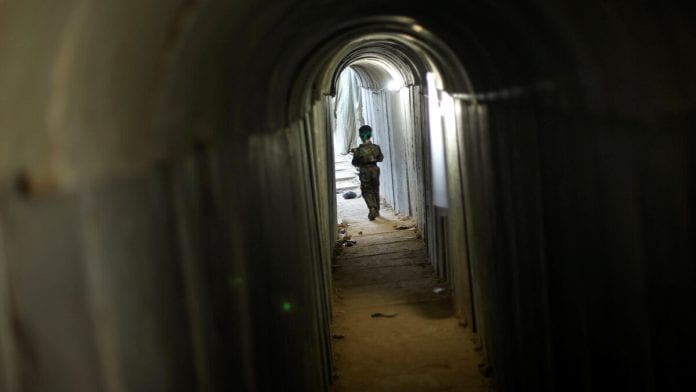 Palestinian boy walks in a tunnel as he takes part in a military exercise graduation ceremony at a summer camp organised by Hamas's armed wing, east of Gaza City