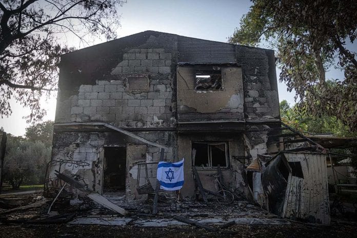 Destruction-at-Kibbutz-Beeri-With-Israeli-Flag-1320x880