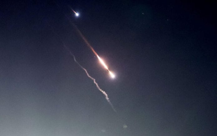 Objects are seen in the sky above Jerusalem after Iran launched drones and missiles towards Israel, in Jerusalem
