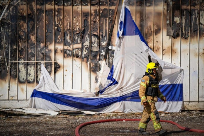 Firefighters-outside-a-warehouse-that-had-been-destroyed-by-a-missiles-attack-from-Lebanon-in-the-northern-Israeli-city-of-Kiryat-Shmona-September-24-2024.-696x464