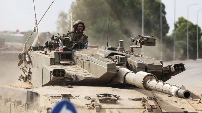 Israeli soldiers drive in a tank by Israel's border with Gaza in southern Israel