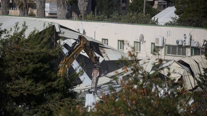 a-photograph-shows-machinery-demolishing-a-structure-inside-the-headquarters-of-the-united-nations-r-1768897678_260c106c3f696ca0c106c3f69811c1v_