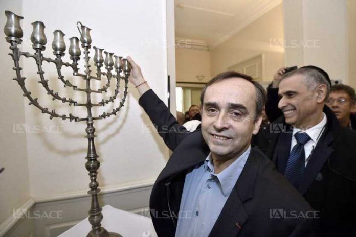 robert-menard-a-allume-l-une-des-bougies-de-la-hanoukkia-installee-dans-le-hall-de-la-mairie-de-beziers-photo-afp-pascal-guyot-1418750422_833_556