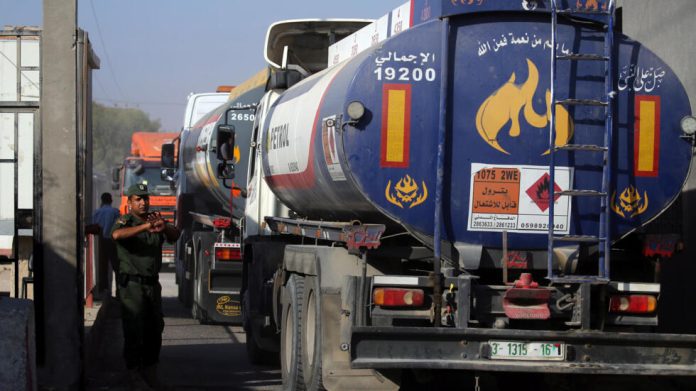Member of Palestinian security forces gestures as a fuel tanker arrives at Kerem Shalom crossing in Rafah in the southern Gaza Strip
