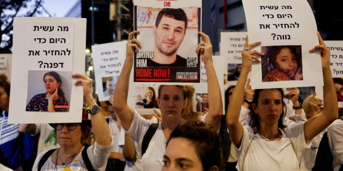Israeli youth prepare an art installation of teddy bears with pictures of hostages, in Tel Aviv