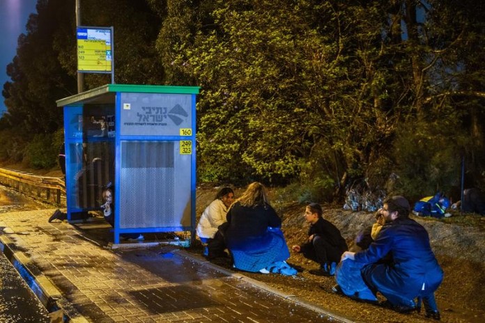 Israelis-crouch-on-the-side-of-the-road-near-Rehovot-as-siren-are-sounded-warning-of-an-incoming-missile-fired-from-Yemen-December-30-2024.-696x464 (1)